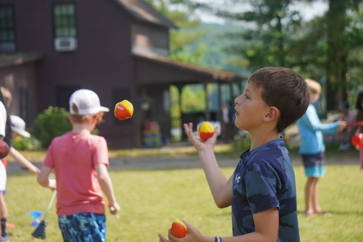 Kid playing with tennis balls at Camp Billings
