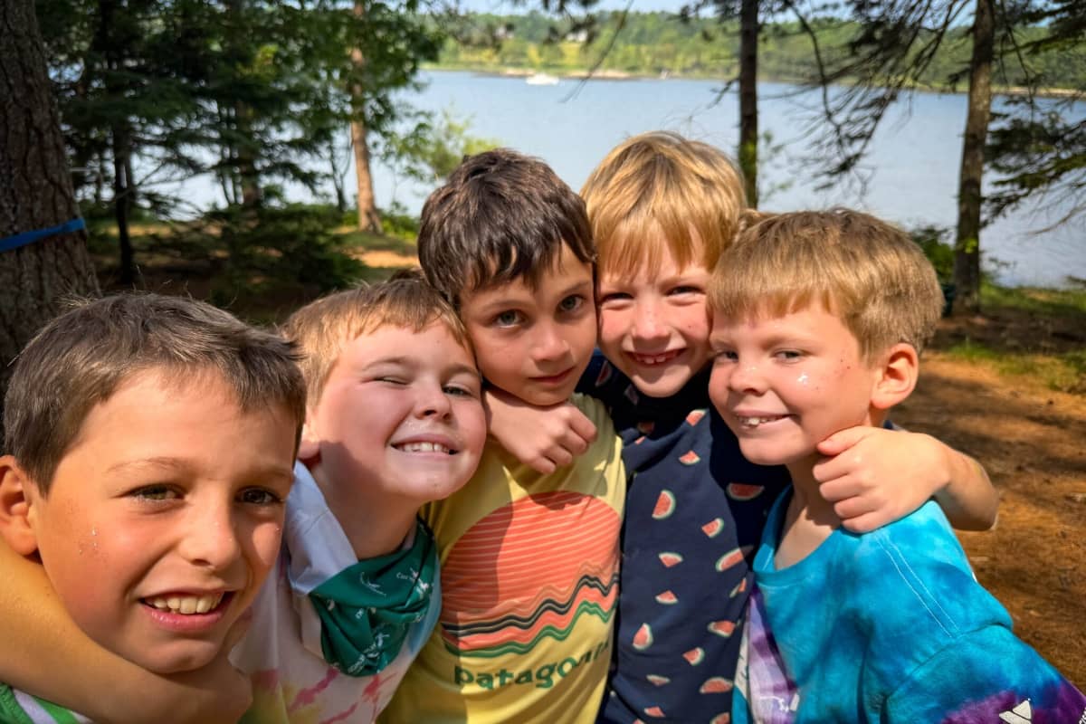 Boy campers hugging one another