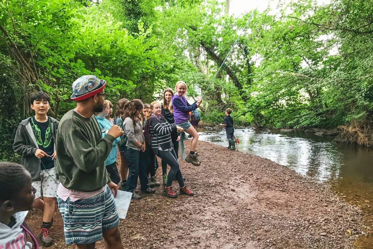 Camp counselor with kids by the river