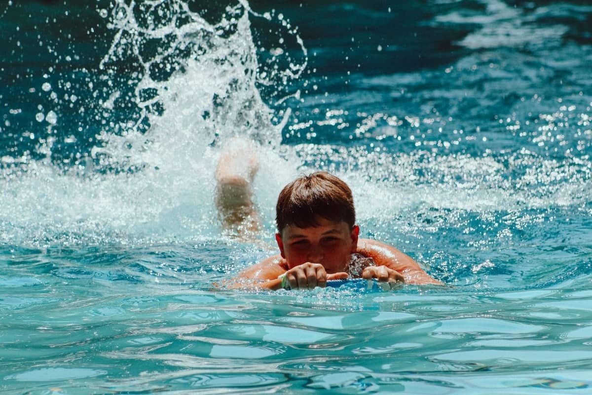 Boy swimming at a pool in Camp Olympia