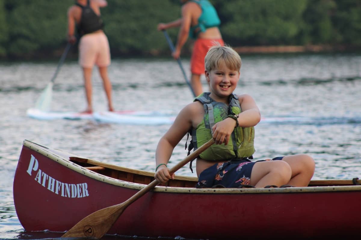 Boy rowing a canoe at Camp Pathfinder