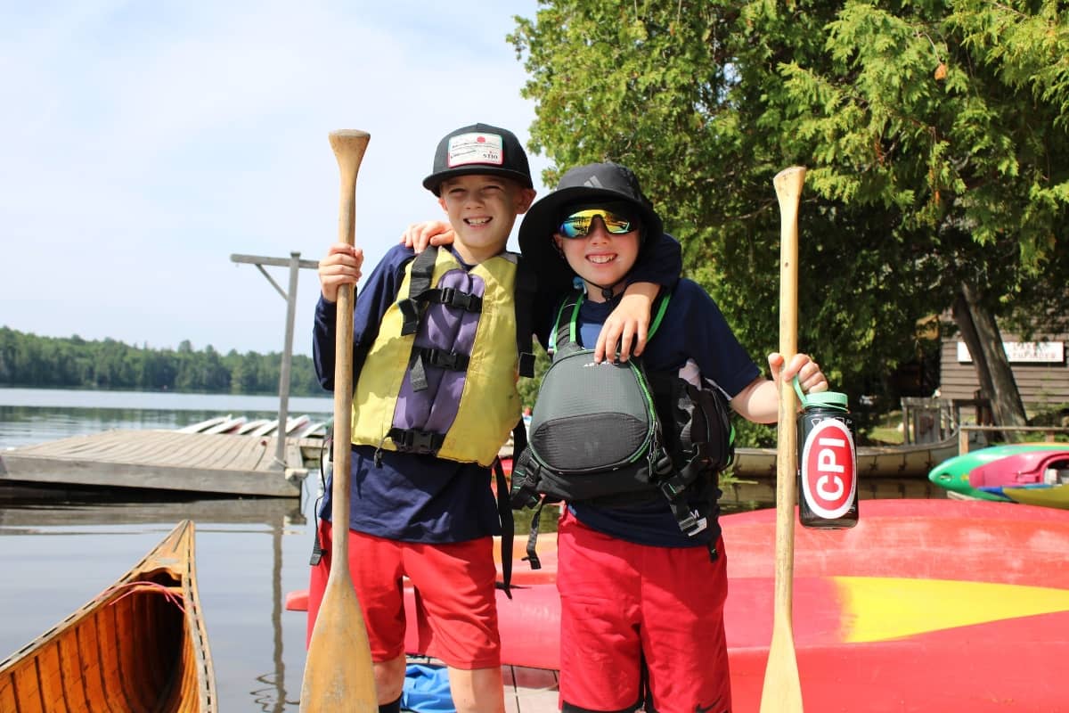 Kids taking a photo with canoe rowing equipment