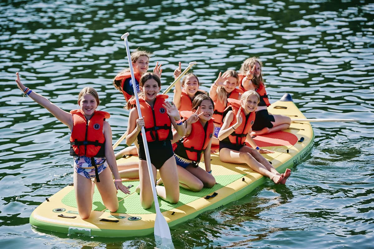Group of kids paddle boarding at Camp Qwanoes
