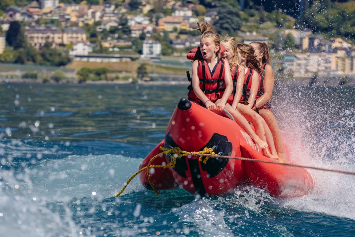 Girls on a boat float being pulled by the boat
