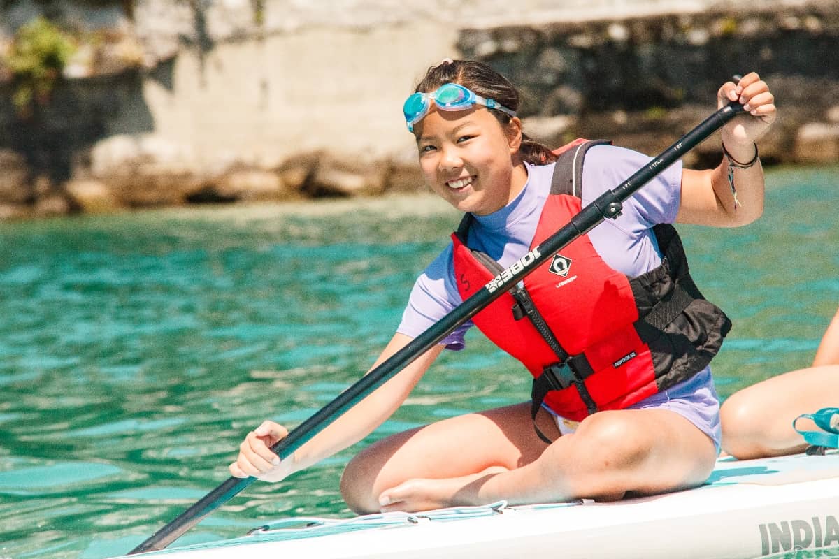 Girl paddleboarding at the lake