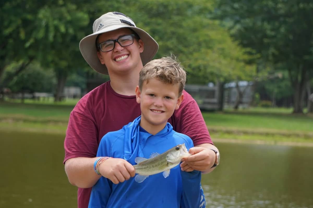 Kid fishing with camp counselor