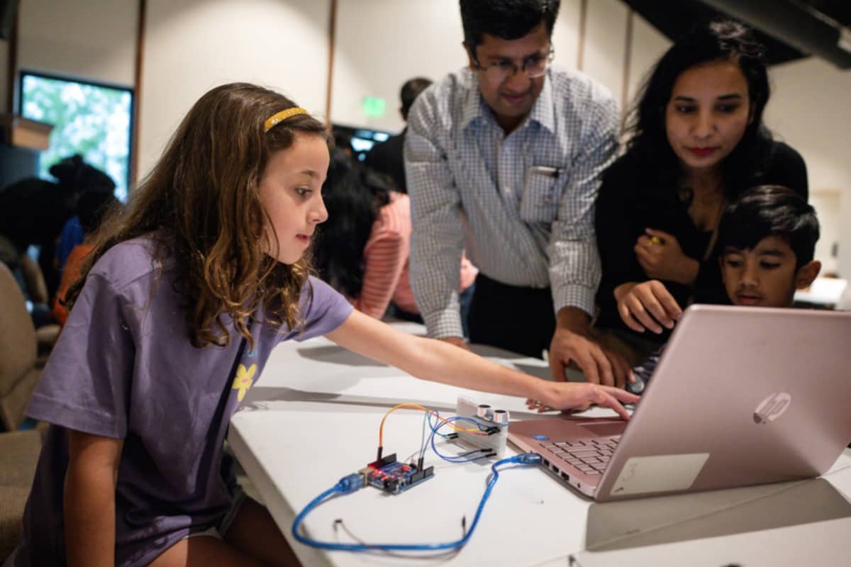Girl showing her coding project to family