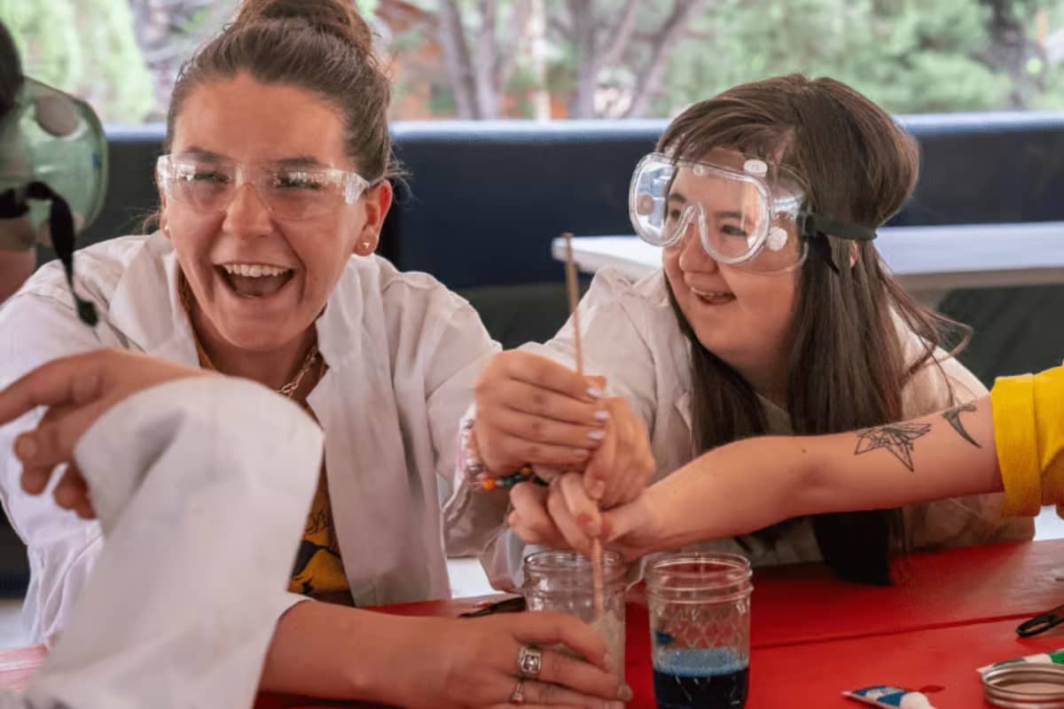 Camper working on science project with counselor