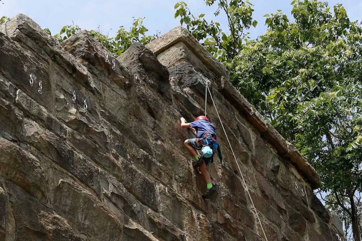 Young camper going rock climbing