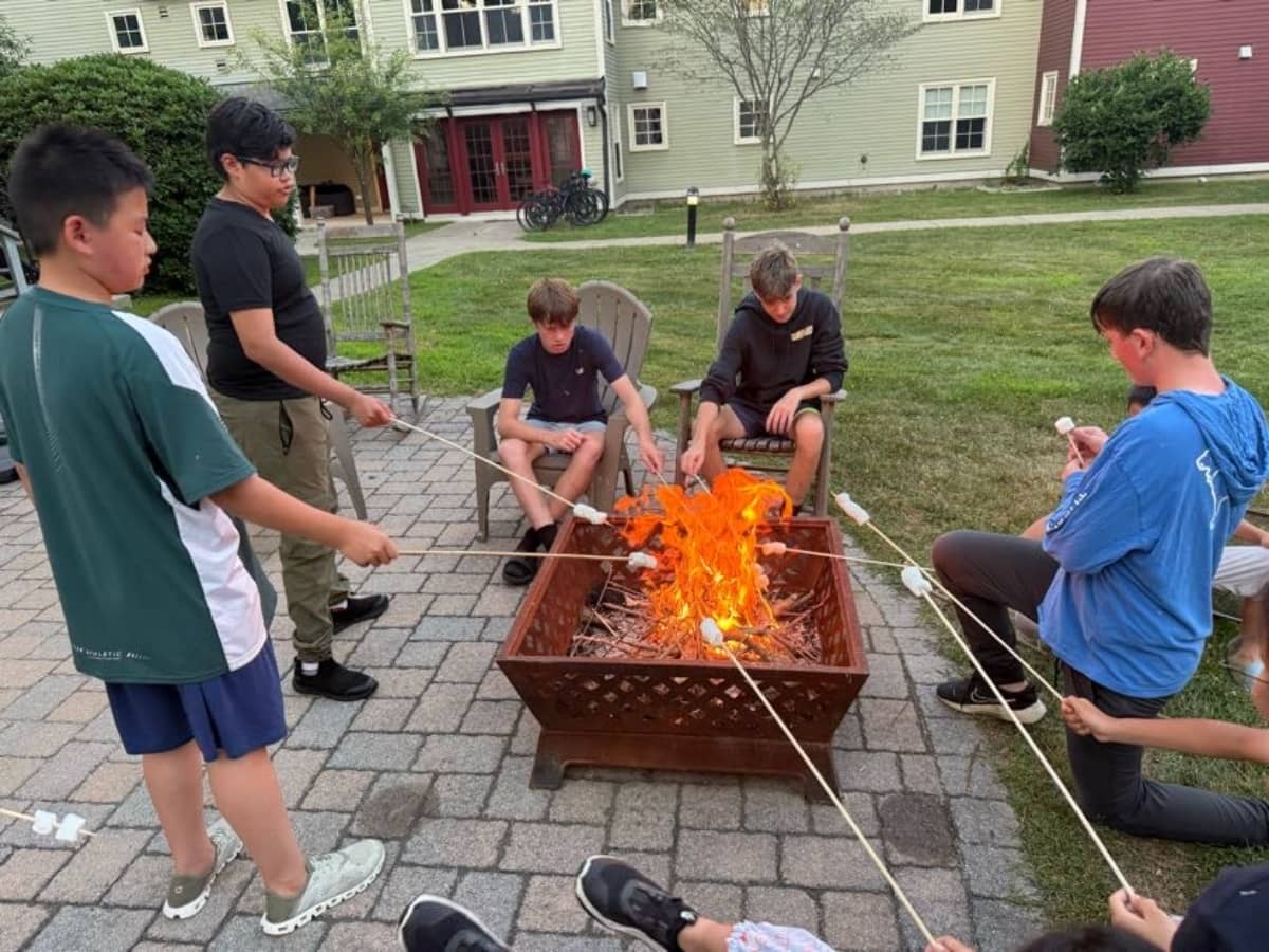 Campers roasting marshmellows over the fire