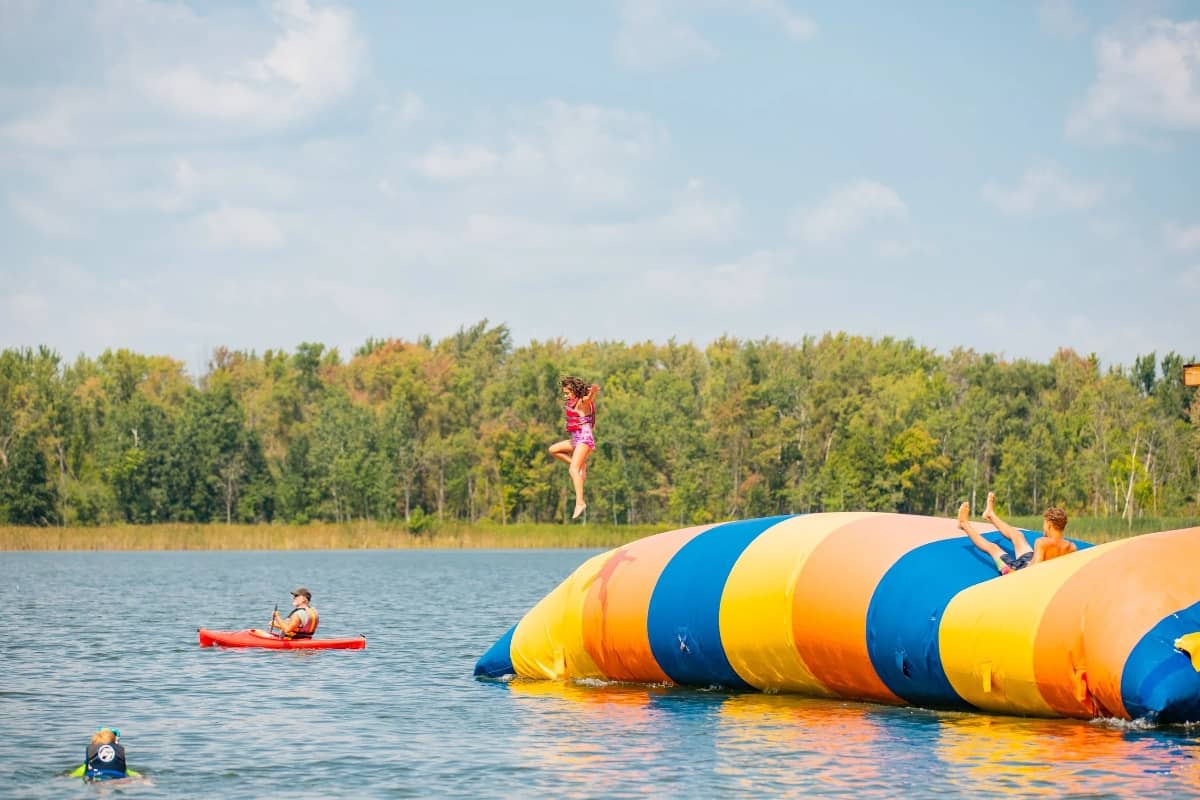 Girl using the jumping pillow for the lake