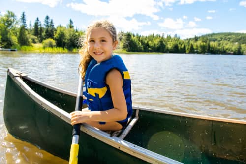 Child paddling at a lake
