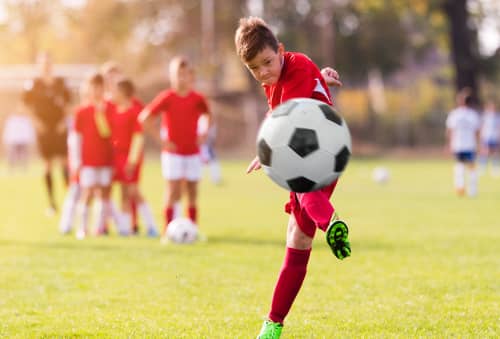 kid kicking soccer ball