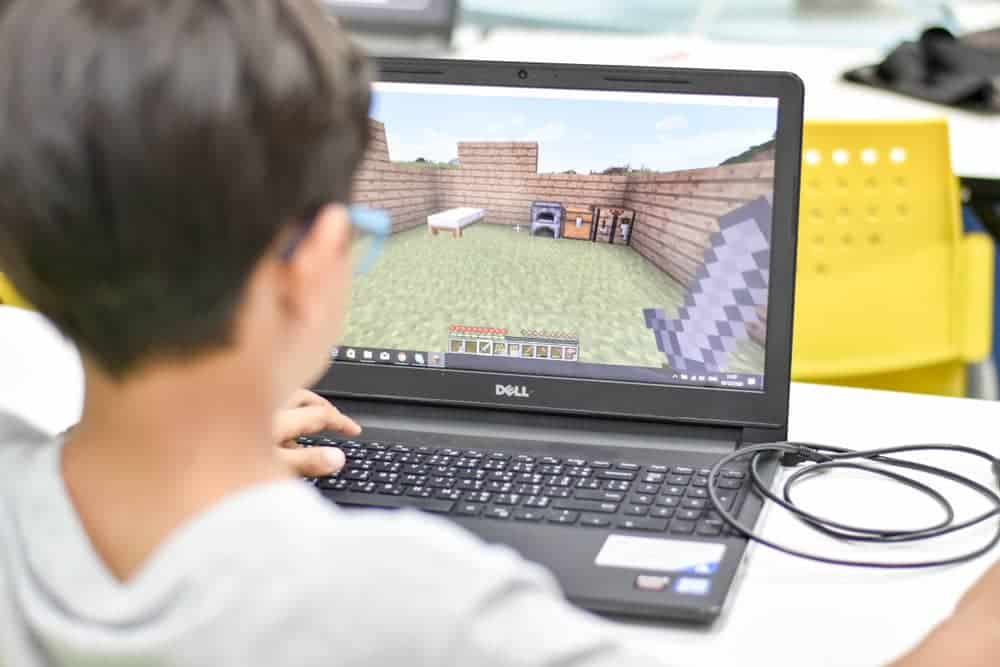 Kid playing Minecraft on computer